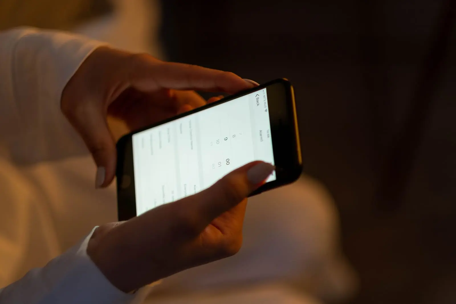 Manos sostienen un celular en horizontal con una interfaz de aplicación en pantalla blanca
